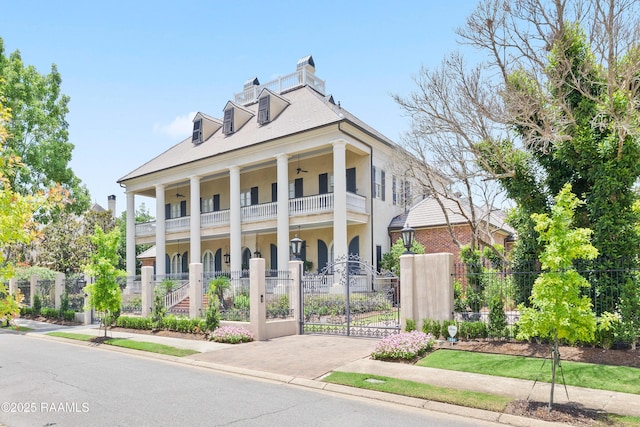 232 Princeton Woods Loop, Lafayette, LA 70508 - greek revival inspired property with a balcony, a fenced front yard, a porch, a gate, and a chimney