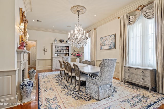 232 Princeton Woods Loop, Lafayette, LA 70508 - dining area with a decorative wall, a chandelier, wainscoting, crown molding, and wood finished floors