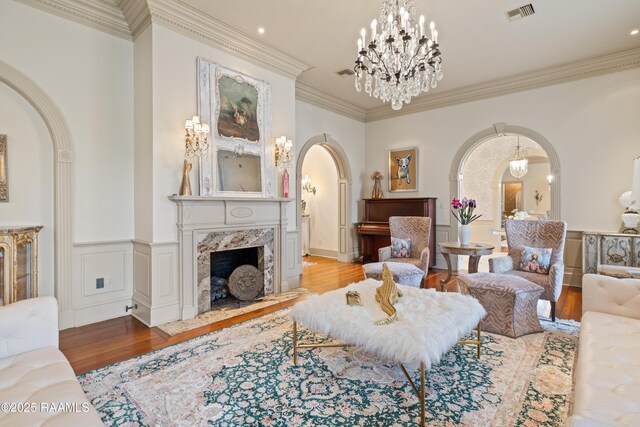 232 Princeton Woods Loop, Lafayette, LA 70508 - living area featuring arched walkways, light wood-type flooring, crown molding, a fireplace, and a chandelier