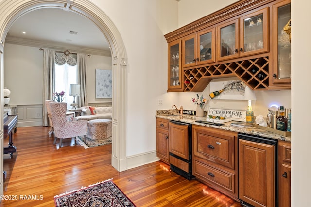 232 Princeton Woods Loop, Lafayette, LA 70508 - indoor wet bar with arched walkways, ornamental molding, wood-type flooring, wine cooler, and range with electric stovetop