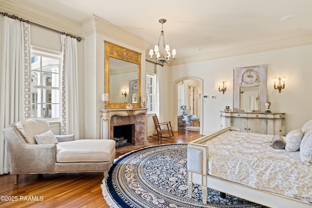 232 Princeton Woods Loop, Lafayette, LA 70508 - bedroom with arched walkways, wood finished floors, crown molding, a premium fireplace, and a chandelier