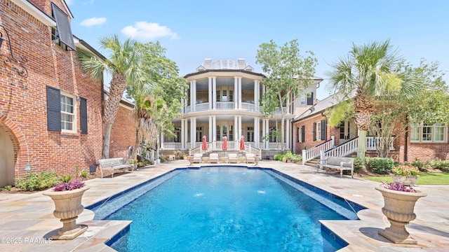 232 Princeton Woods Loop, Lafayette, LA 70508 - rear view of house featuring a balcony, an outdoor pool, brick siding, and a patio