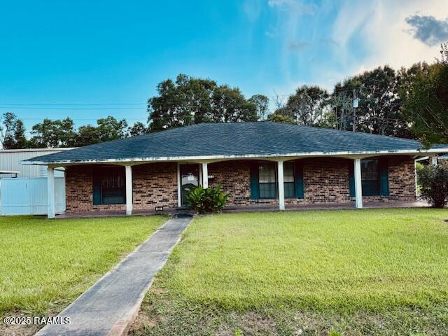 122 Progress Rd, Ville Platte, LA 70586 - ranch-style house featuring a front lawn, brick siding, and covered porch