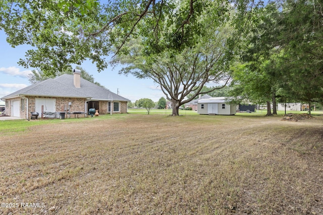 104 Briarfield Dr, Carencro, LA 70520 - view of grassy yard featuring a storage shed and an attached garage