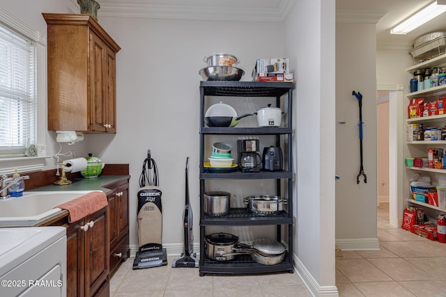 104 Briarfield Dr, Carencro, LA 70520 - laundry area featuring cabinet space, washer / dryer, ornamental molding, and light tile patterned floors