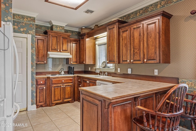 104 Briarfield Dr, Carencro, LA 70520 - kitchen featuring under cabinet range hood, wallpapered walls, light tile patterned floors, gas cooktop, and tile countertops