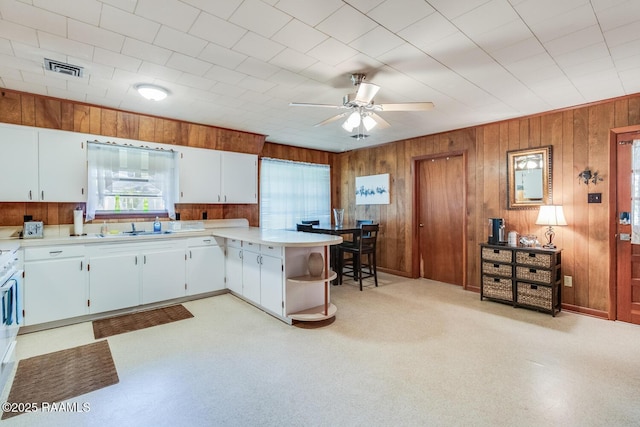 107 Julenie Way, Youngsville, LA 70592 - kitchen featuring light countertops, a ceiling fan, wood walls, open shelves, and a peninsula