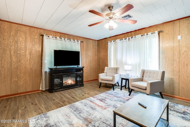 107 Julenie Way, Youngsville, LA 70592 - living area with wood walls, ceiling fan, wood finished floors, and a glass covered fireplace