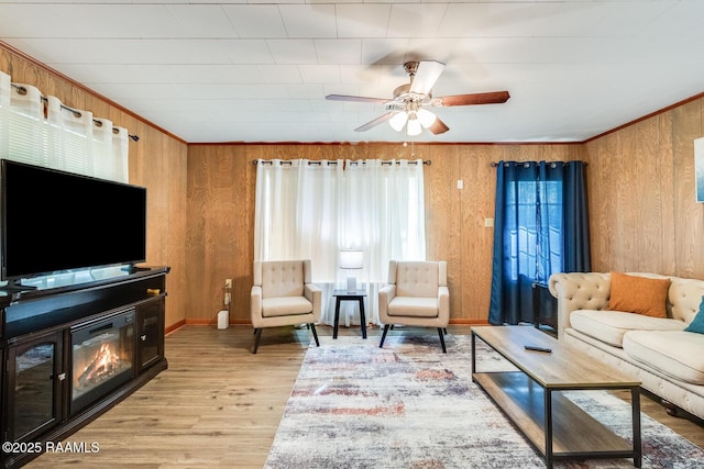107 Julenie Way, Youngsville, LA 70592 - living room featuring light wood finished floors, wood walls, a ceiling fan, and ornamental molding
