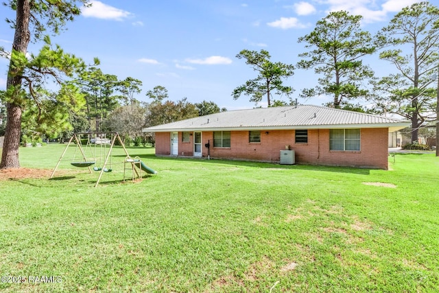 107 Julenie Way, Youngsville, LA 70592 - back of property with a playground, a lawn, and brick siding