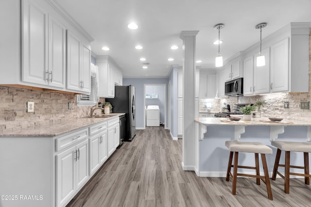 177 Radcliffe Dr, Lafayette, LA 70501 - kitchen featuring appliances with stainless steel finishes, white cabinets, a peninsula, tasteful backsplash, and recessed lighting