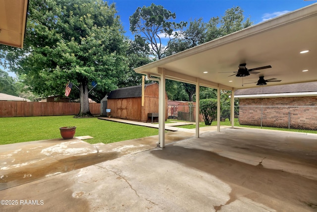 177 Radcliffe Dr, Lafayette, LA 70501 - fenced backyard with ceiling fan, a storage unit, and a patio