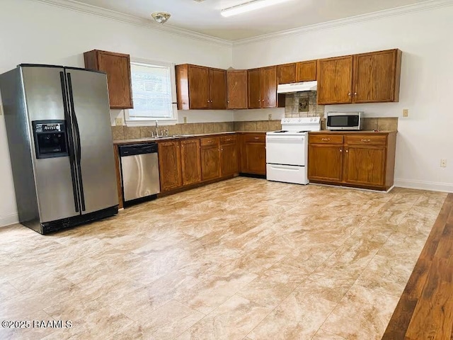 1108 Poydras Pl, Breaux Bridge, LA 70517 - kitchen with stainless steel appliances, under cabinet range hood, crown molding, and brown cabinets