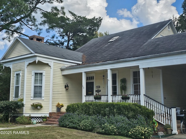 118 Pollard Ave, New Iberia, LA 70563 - view of front of property featuring a porch, a shingled roof, and a chimney