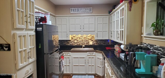 118 Pollard Ave, New Iberia, LA 70563 - kitchen with freestanding refrigerator, dark countertops, decorative backsplash, and white cabinets
