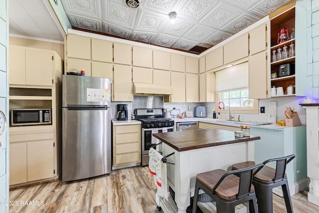 1054 Main St, Parks, LA 70582 - kitchen with appliances with stainless steel finishes, wooden counters, cream cabinets, open shelves, and ornamental molding