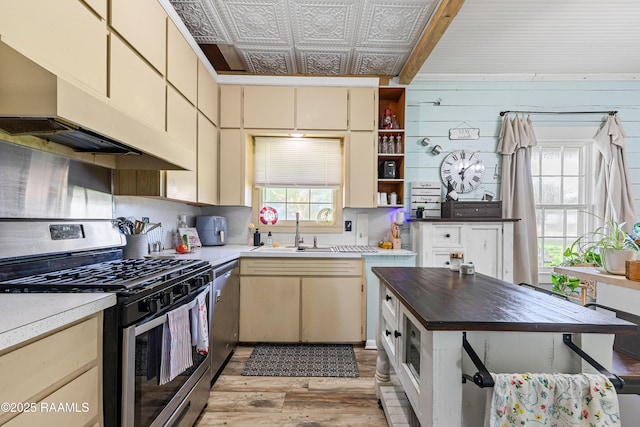 1054 Main St, Parks, LA 70582 - kitchen featuring stainless steel appliances, cream cabinetry, light wood-style floors, under cabinet range hood, and butcher block countertops