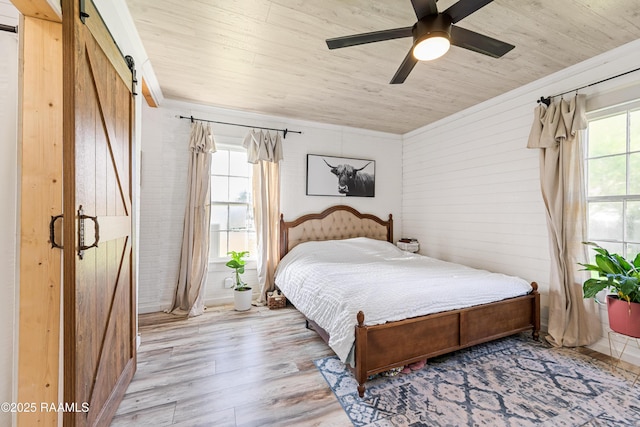 1054 Main St, Parks, LA 70582 - bedroom featuring a barn door, wood ceiling, wood finished floors, and a ceiling fan