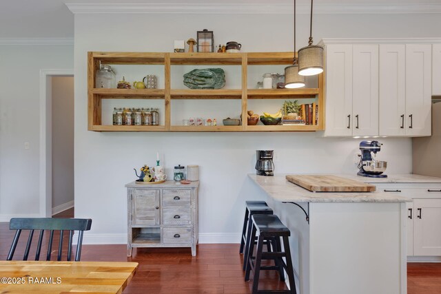 124 Buttercup Dr, Washington, LA 70589 - kitchen with open shelves, white cabinetry, dark wood finished floors, a kitchen breakfast bar, and ornamental molding