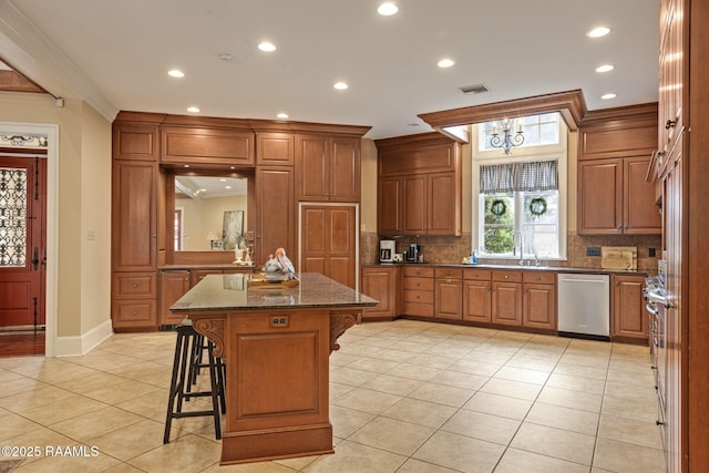 2 Carmel Bnd, New Iberia, LA 70563 - kitchen with stainless steel dishwasher, a breakfast bar, decorative backsplash, ornamental molding, and light tile patterned floors