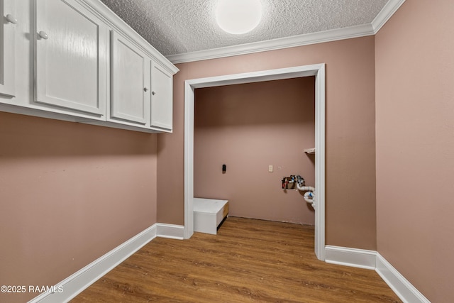 1243 Huval Rd, Breaux Bridge, LA 70517 - laundry area with hookup for an electric dryer, a textured ceiling, dark wood-type flooring, and crown molding