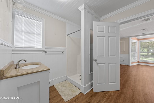 1243 Huval Rd, Breaux Bridge, LA 70517 - full bath featuring wood finished floors, a stall shower, crown molding, a wainscoted wall, and vanity