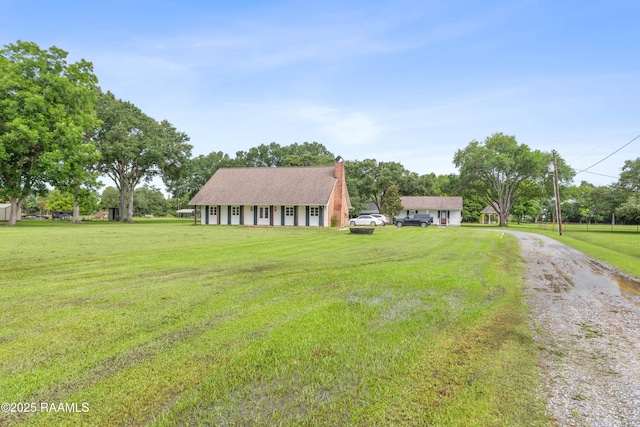 1243 Huval Rd, Breaux Bridge, LA 70517 - view of front facade featuring driveway, a chimney, and a front yard