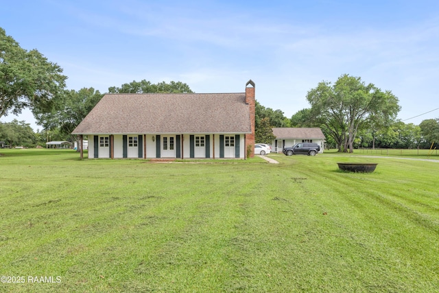1243 Huval Rd, Breaux Bridge, LA 70517 - view of front of property featuring a front lawn, a chimney, a shingled roof, and covered porch