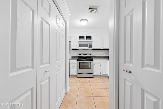 15 Courtyard Cir, Lafayette, LA 70508 - kitchen featuring stainless steel range with electric stovetop, dark countertops, white cabinets, crown molding, and light tile patterned floors