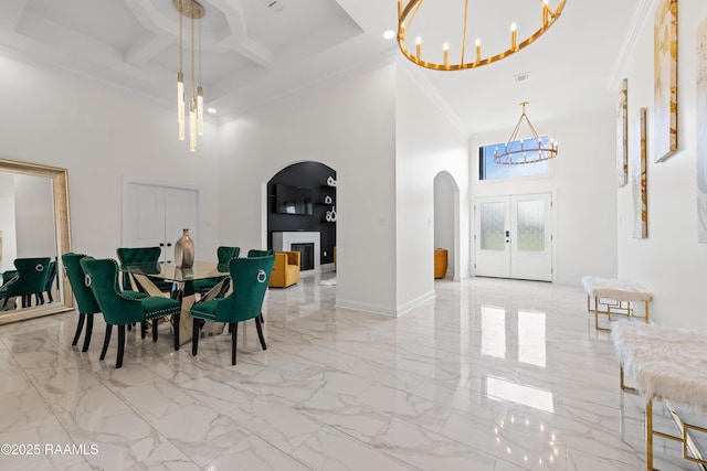 1114 Dermelie Calais Rd, Breaux Bridge, LA 70517 - dining space with a chandelier, a high ceiling, arched walkways, ornamental molding, and marble finish flooring