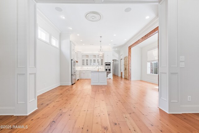 106 Brickell Way, Lafayette, LA 70508 - kitchen with appliances with stainless steel finishes, light countertops, white cabinets, light wood-type flooring, and crown molding