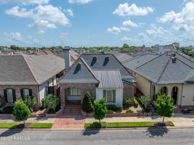 106 Brickell Way, Lafayette, LA 70508 - french country inspired facade with a residential view, a chimney, brick siding, roof with shingles, and stucco siding