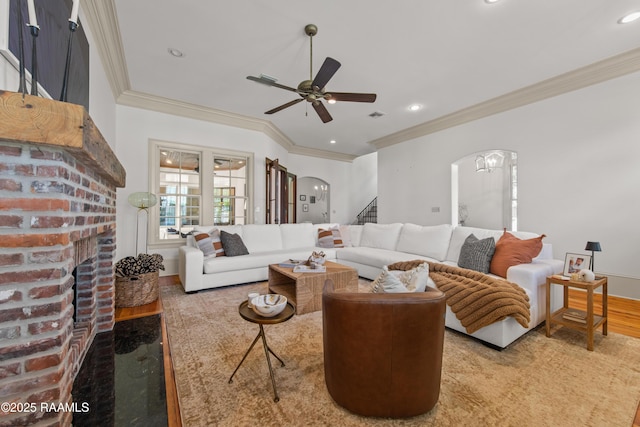 407 Arabella Blvd, Lafayette, LA 70508 - living room featuring arched walkways, a brick fireplace, a ceiling fan, stairway, and crown molding