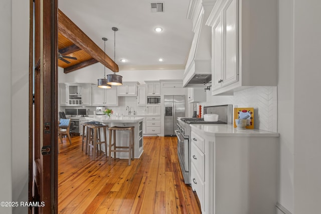 407 Arabella Blvd, Lafayette, LA 70508 - kitchen featuring stainless steel appliances, a kitchen breakfast bar, light countertops, light wood-type flooring, and backsplash