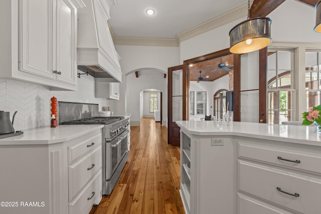 407 Arabella Blvd, Lafayette, LA 70508 - kitchen with double oven range, premium range hood, arched walkways, white cabinets, and crown molding