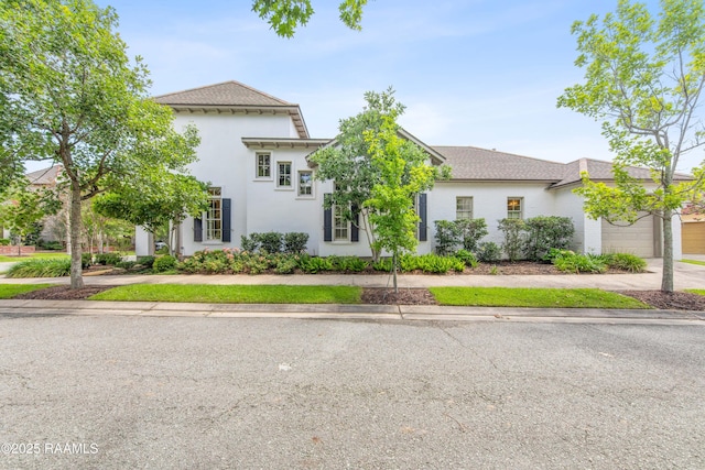 407 Arabella Blvd, Lafayette, LA 70508 - view of front facade with an attached garage, stucco siding, and driveway