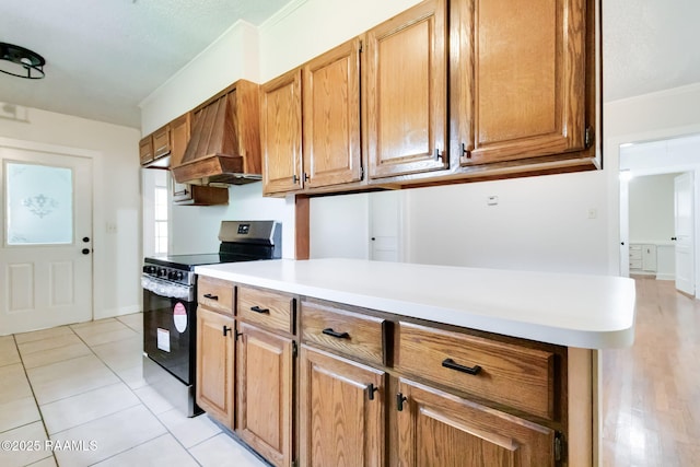 707 Compton St, New Iberia, LA 70560 - kitchen with electric stove, custom range hood, crown molding, light countertops, and brown cabinets