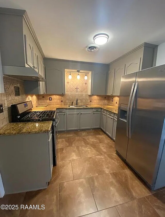 1317 N N Elton Ct, Lake Charles, LA 70607 - kitchen featuring appliances with stainless steel finishes, gray cabinetry, tasteful backsplash, dark stone countertops, and under cabinet range hood