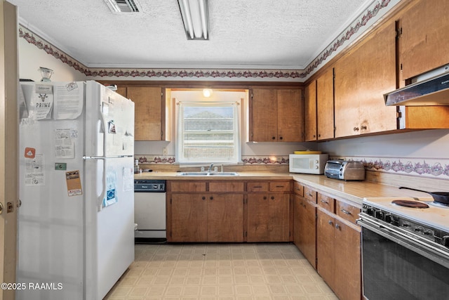 701 Ledoux St, Jennings, LA 70546 - kitchen with white appliances, light floors, light countertops, brown cabinets, and a textured ceiling
