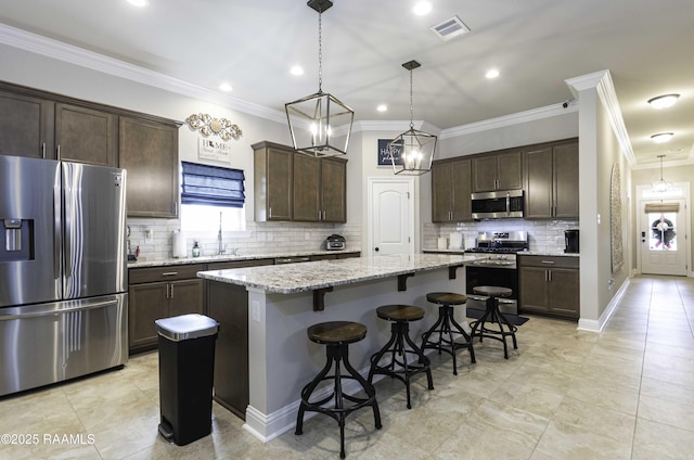 100 Rose Of Sharon Ln, Lafayette, LA 70508 - kitchen featuring stainless steel appliances, dark brown cabinets, a kitchen island, a breakfast bar area, and decorative backsplash