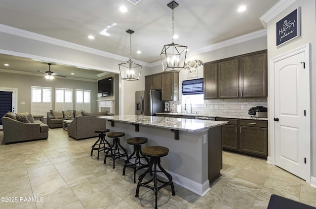 100 Rose Of Sharon Ln, Lafayette, LA 70508 - kitchen with stainless steel refrigerator with ice dispenser, a breakfast bar, dark brown cabinets, backsplash, and a center island