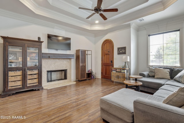 103 Majestic Oaks Dr, Broussard, LA 70518 - living room with a tray ceiling, wood finished floors, ornamental molding, a ceiling fan, and a premium fireplace