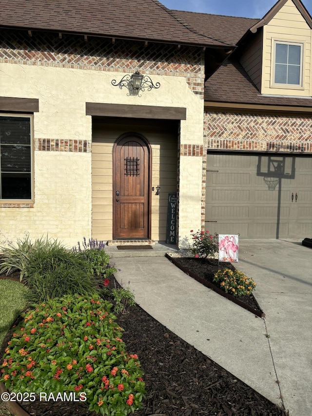 103 Majestic Oaks Dr, Broussard, LA 70518 - doorway to property featuring a garage, driveway, brick siding, and a shingled roof
