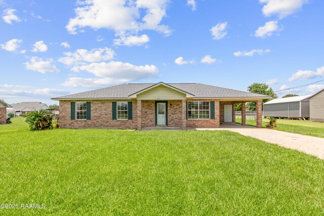 189 Jeremy Rd, Opelousas, LA 70570 - ranch-style house featuring concrete driveway, a front yard, an attached carport, roof with shingles, and brick siding