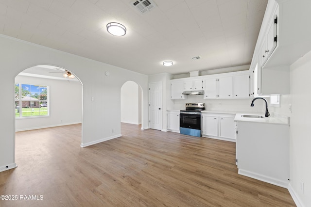 189 Jeremy Rd, Opelousas, LA 70570 - kitchen with electric range, arched walkways, open floor plan, light wood-type flooring, and light countertops