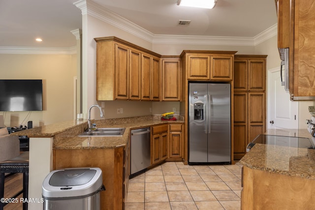 742 Hummingbird Ln, New Iberia, LA 70563 - kitchen with stainless steel appliances, brown cabinetry, stone countertops, a peninsula, and ornamental molding