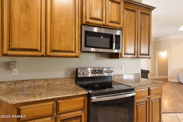 742 Hummingbird Ln, New Iberia, LA 70563 - kitchen with appliances with stainless steel finishes, brown cabinetry, and crown molding