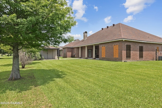 742 Hummingbird Ln, New Iberia, LA 70563 - rear view of house with a lawn, a chimney, and brick siding