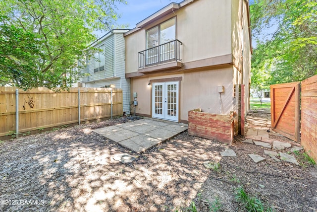 313 Sidney Martin Rd, Lafayette, LA 70507 - back of house featuring french doors, a balcony, a fenced backyard, a patio area, and stucco siding