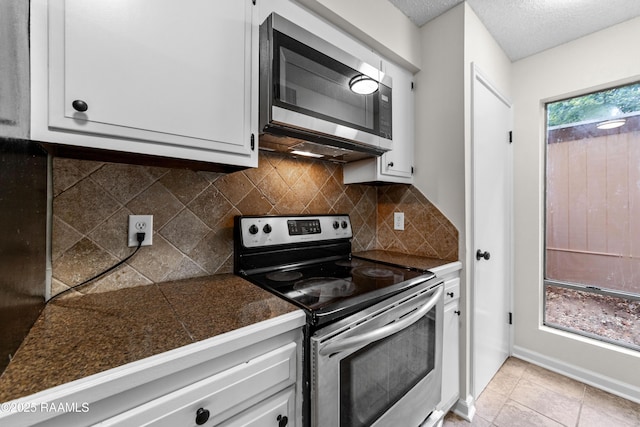 313 Sidney Martin Rd, Lafayette, LA 70507 - kitchen featuring appliances with stainless steel finishes, tile counters, white cabinetry, backsplash, and light tile patterned flooring